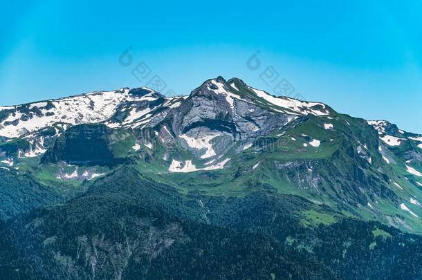 高的山和绿色的斜坡和下雪的山峰
