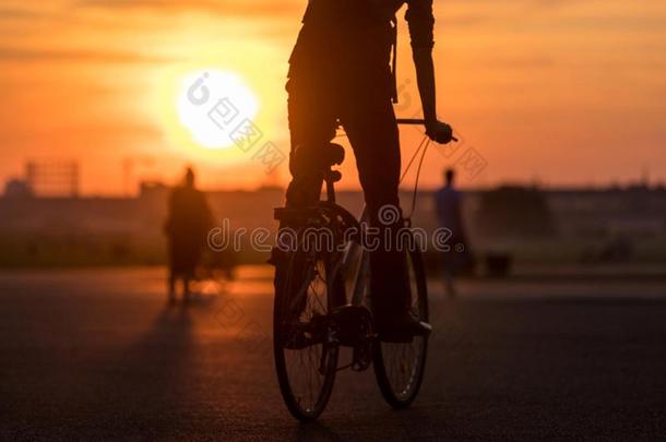 傍晚城市日落和一自行车-骑手