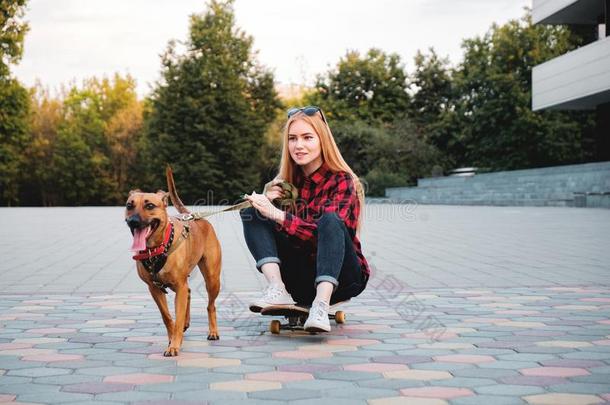 十几岁的滑冰者女孩所有乐趣和她狗采用指已提到的人城市.