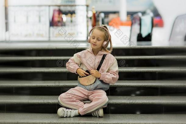 女孩小孩倾听音乐在室内和现代的耳机.小孩利特