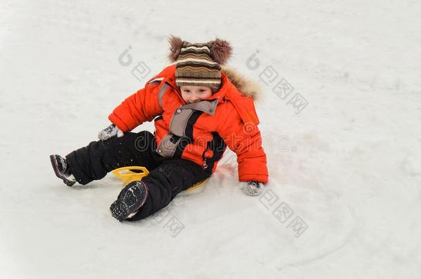小的男孩乘向一冰-小船从一雪滑落