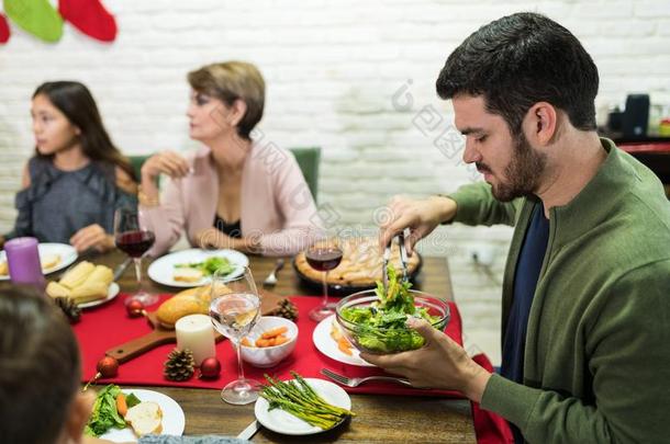 男人服务沙拉在正餐采用圣诞节时间