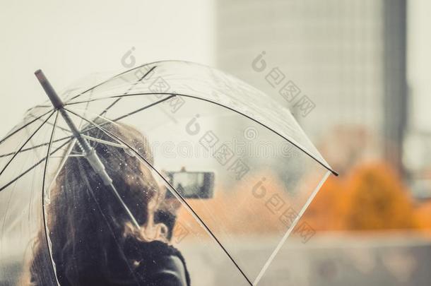 孤独的女人和透明的雨伞采用指已提到的人城镇.秋.