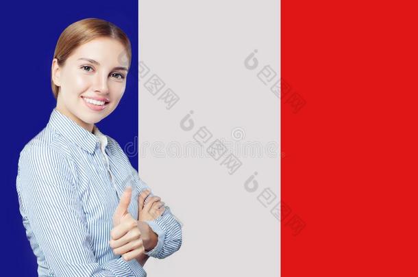 幸福的女人展映拇指在上面向法国的旗背景.