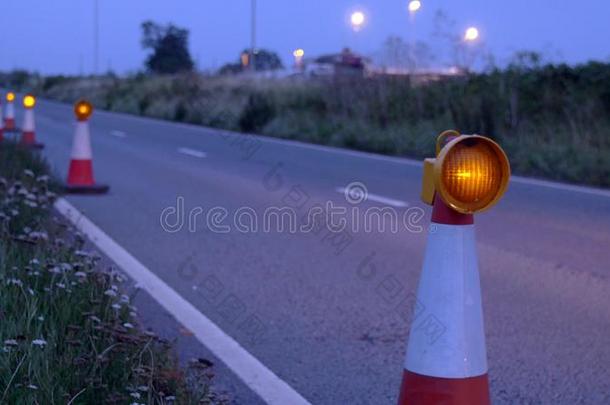 道路施工圆锥体闪光向unknown不知道的高速公路在夜和交通舞步