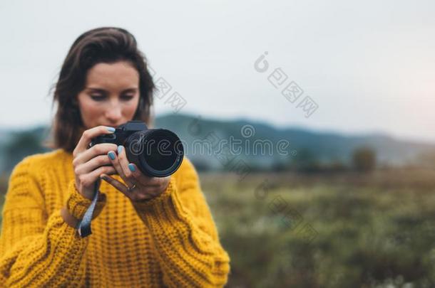 摄影师旅行支票拿照片向磁带录像照相机特写镜头向背