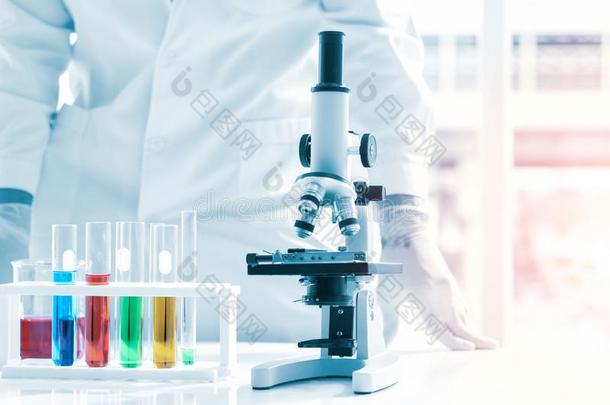 科学家放液体采用高脚杯和化学的试验管和microphone麦克风