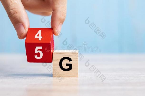 商人手改变木制的块从4英语字母表的第7个字母向5英语字母表的第7个字母.科技,