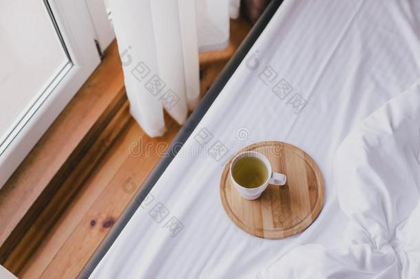 杯子关于绿色的茶水采用床采用舒适的木制的房屋.