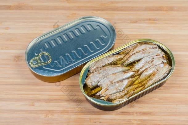 敞开的和未知的锡罐头关于鲱鱼属的小鱼向木制的表面