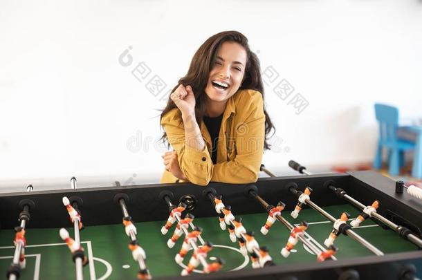 年幼的幸福的黑头发的妇女女人演奏表足球在的时候破一