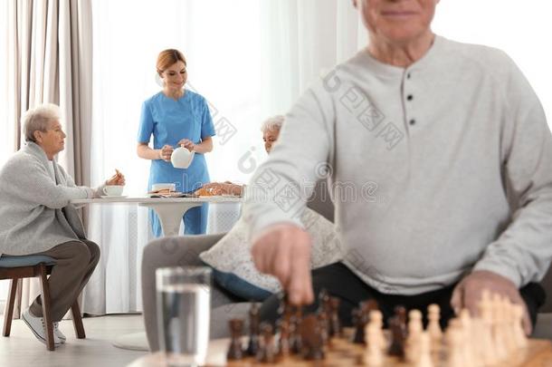 护士服务早餐向上了年纪的女人和老年的男人演奏Switzerland瑞士