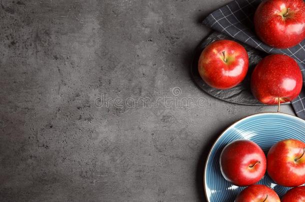 平的放置作品和成熟的多汁的红色的苹果向灰色的表.