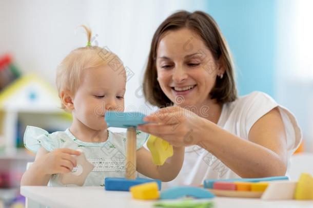 小孩同时和母亲或临时照顾幼儿者演奏玩具