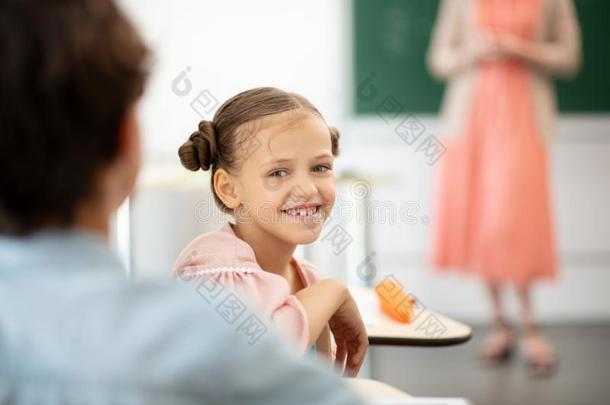 女孩和两个头发圆形的小面包或点心笑的在的时候破在学校