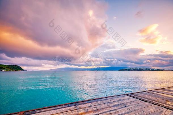 木制的码头,绿松石海,彩色粉笔云和木制的码头在太阳