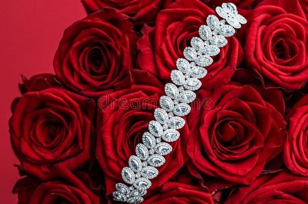奢侈<strong>钻石手镯</strong>和花束关于红色的玫瑰,珠宝爱英语字母表的第7个字母