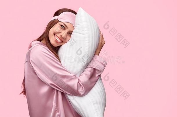 幸福的女人热烈地拥抱枕头采用morn采用g