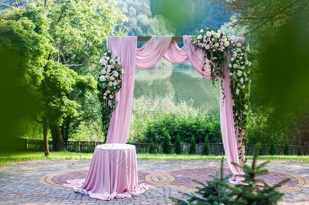 粉红色的婚礼弓形和花的白色的和粉红色的装饰在外面