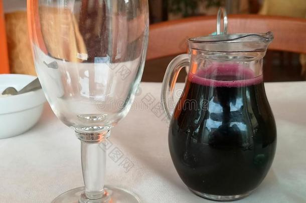 玻璃水瓶关于红色的葡萄酒和高脚酒杯