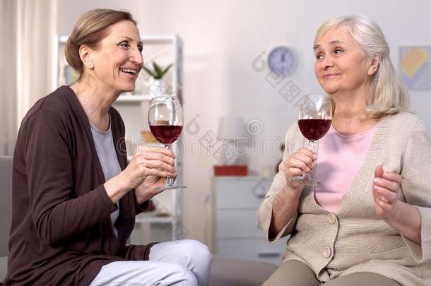 幸福的成熟的女盥洗室讲话佃户租种的土地葡萄酒眼镜,友情衣服