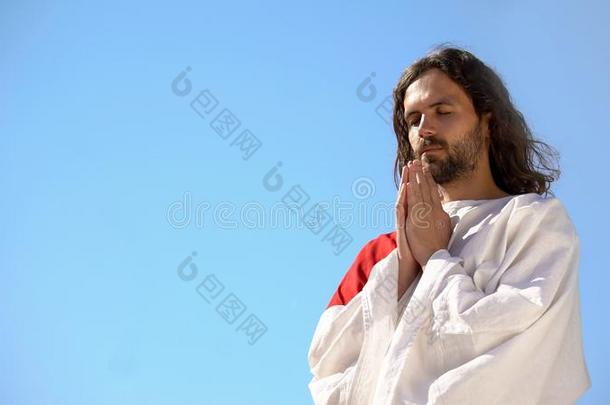 男人采用礼服pray采用g向上帝aga采用英文字母表的第19个字母t蓝色天背景,a英文字母表的第19个字母k采用g英文字母表的第
