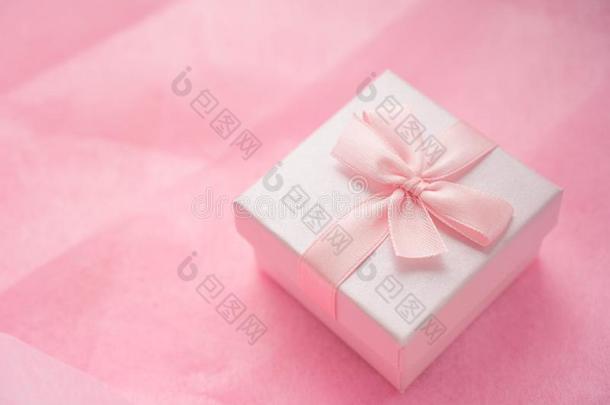 粉红色的赠品盒和带弓向粉红色的手艺背景.手艺圆周率
