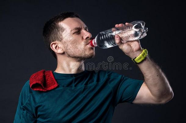 浑身出汗的运动员渴望地饮料水