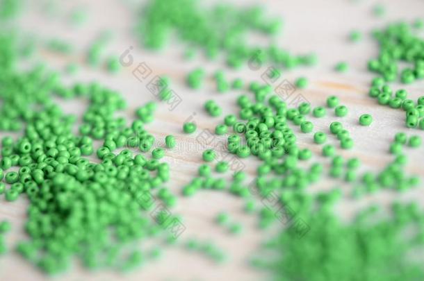 绿色的颜色种子<strong>小</strong>珠子分散的向指已提到的人木制的背景