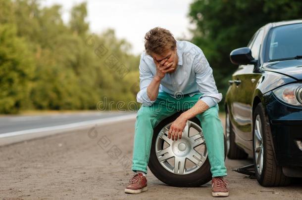 汽车崩溃,疲倦的男人一次向节省轮胎