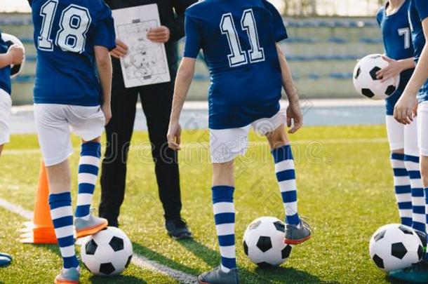 孩子们向足球训练.年幼的足球ers收听的教练