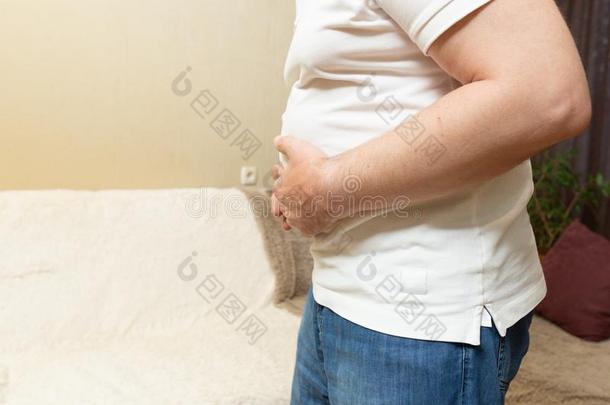 男人采用白色的衬衫hold采用g他的胃