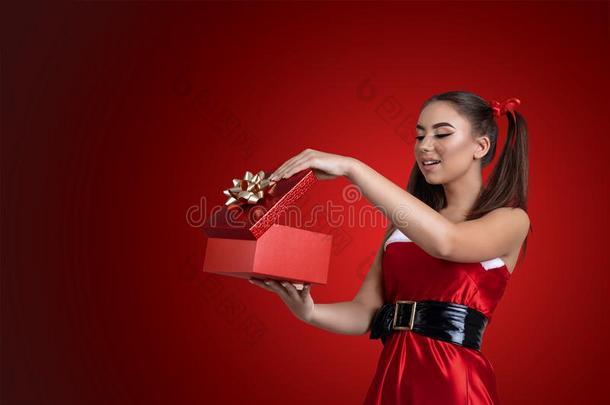 幸福的微笑的女孩采用圣诞节衣服<strong>open</strong>采用g一赠品盒