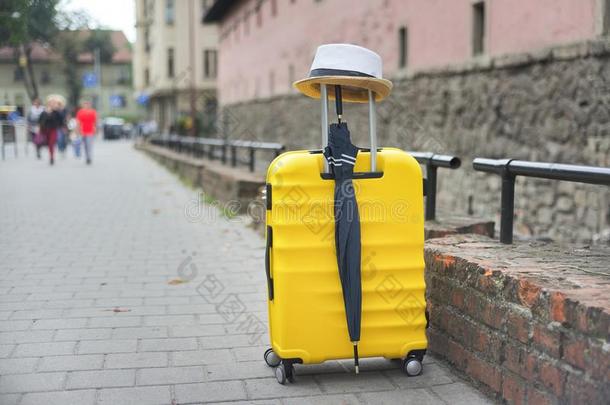 旅行旅游观念,黄色的塑料制品手提箱,帽子,雨伞