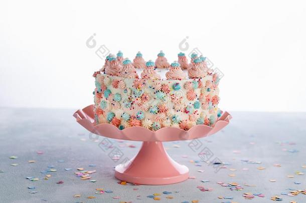白色的生日蛋糕和粉红色的,蓝色结冰和富有色彩的少量