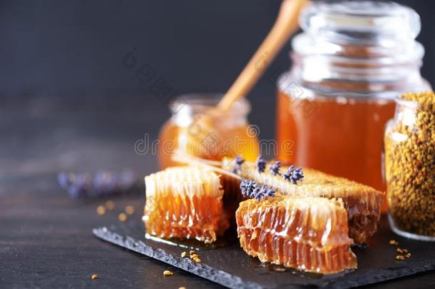 蜜蜂花粉小颗粒,蜂蜜罐子和木制的使滴下的东西,蜂蜜comb向