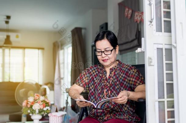 成熟的亚洲人女人使人疲乏的眼镜和阅读一书一t家,关于