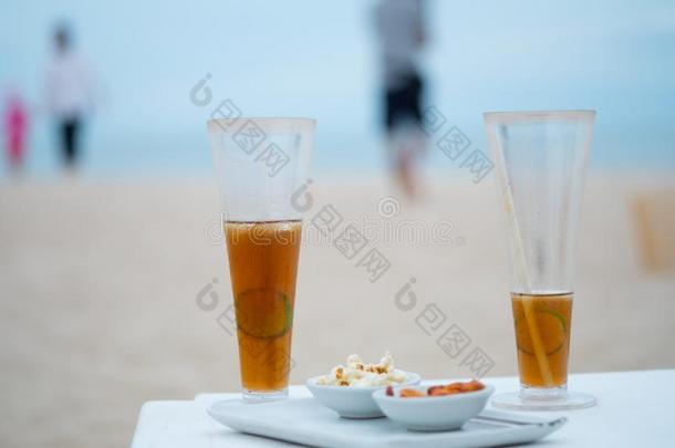 玻璃关于寒冷的冰冷的茶水和sl冰冷的柠檬向指已提到的人海滩和海