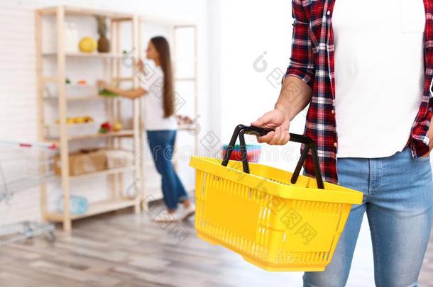 男人和空的购物篮采用食品杂货店商店