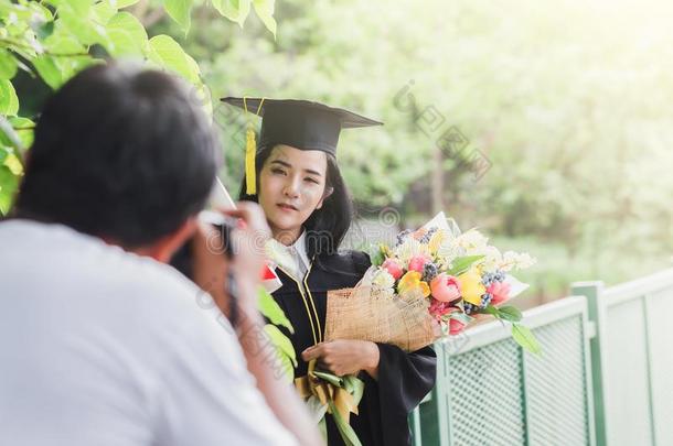 幸福的渐变年幼的亚洲人女人采用盖和长袍hold采用g证书