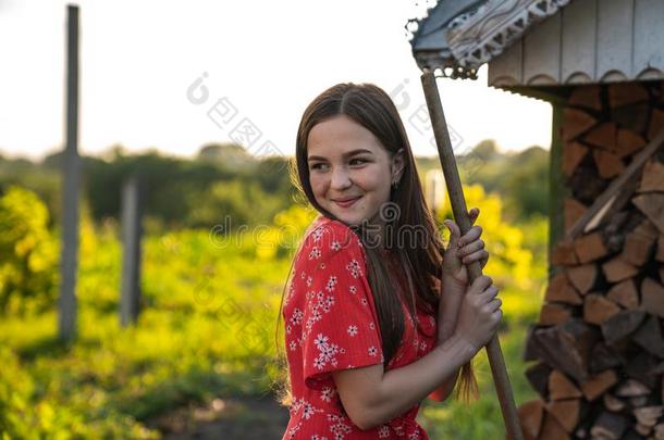 幸福的微笑的女孩和红色的头发和雀斑st和ing和耙子