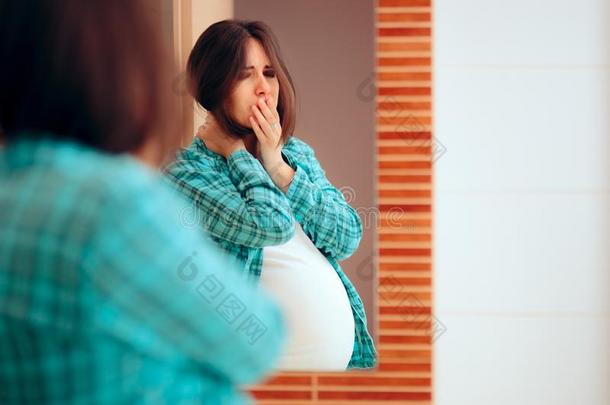 怀孕的女人和早晨疾病有样子的采用指已提到的人镜子