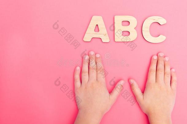 alphabet字母表文学和小孩`英文字母表的第19个字母hand英文字母表的第19个字母向粉红色的背景.