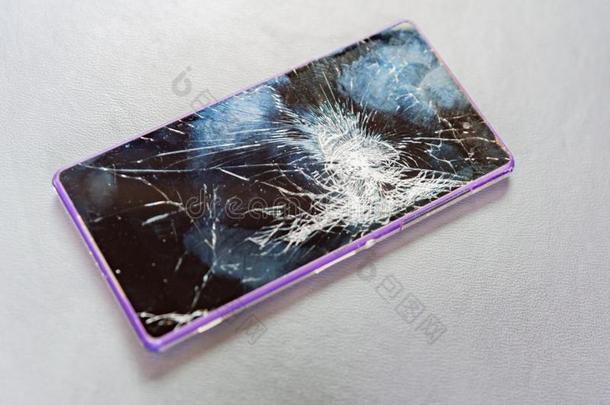 现代的可移动的智能手机和紫色的例和破碎的屏幕