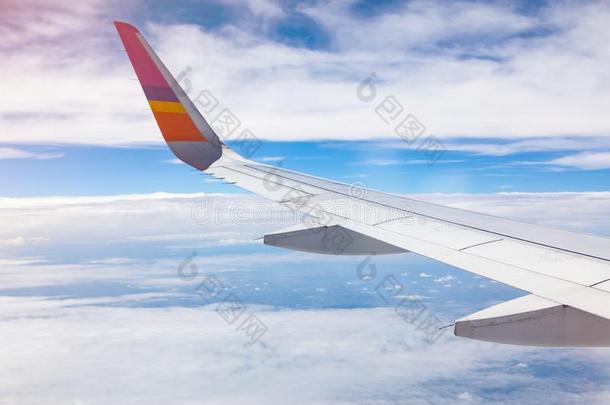 飞机翅膀向蓝色天和白色的云背景