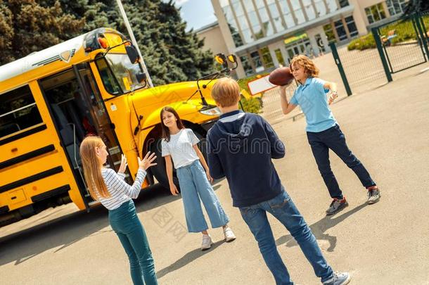 同学起立在近处学校公共汽车演奏美国人足球向