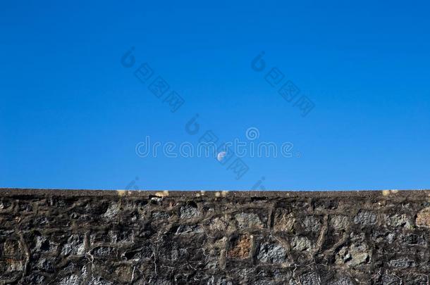 上升的月亮越过古代的石头护墙墙
