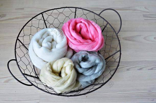 灰色的,粉红色的,香子兰和白色的美利奴羊羊毛采用圆形的金属丝篮