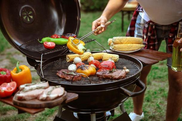 男人烹饪术食物向烤架<strong>烧烤</strong>在户外