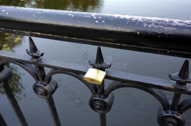 金色的压抑的挂锁悬向黑的金属小矮人栅栏特写镜头